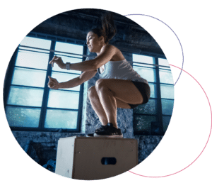 woman jumping on a box in a fitness center