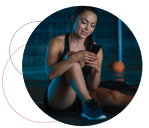 woman looking at phone in a gym