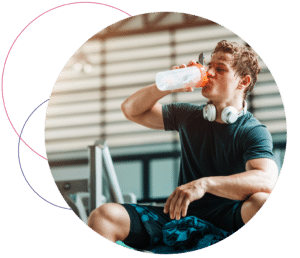 man drinking protein shake in gym