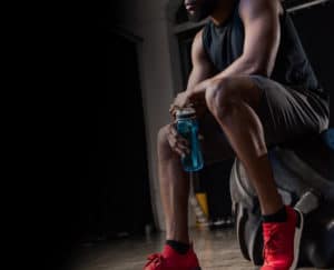 man holding water bottle in a gym